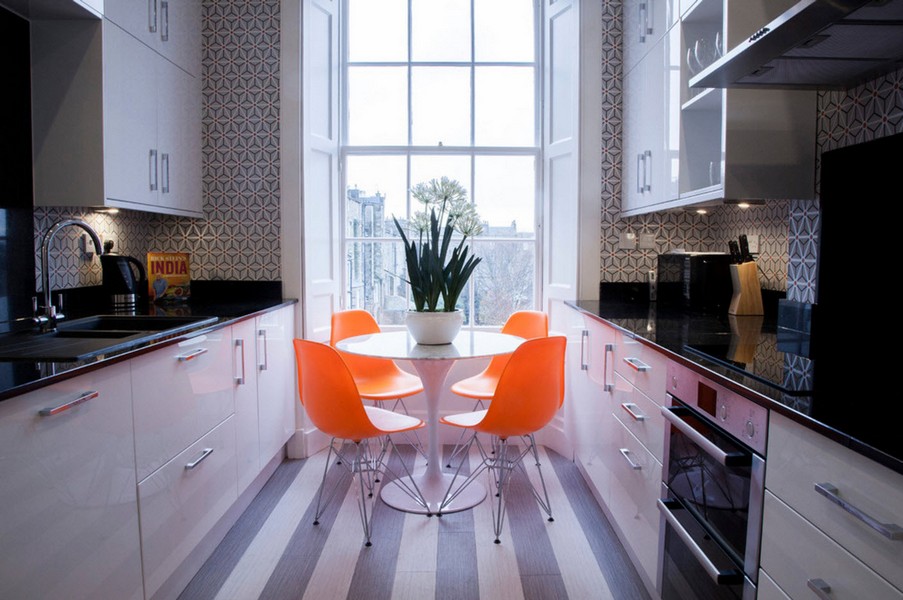 Oranžinės kėdės siauroje lygiagrečioje virtuvėje