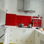 Rode schort in een witte keuken