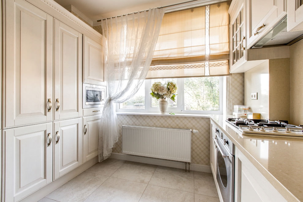 Lys klassiske gardiner på køkkenvinduet i et panelhus