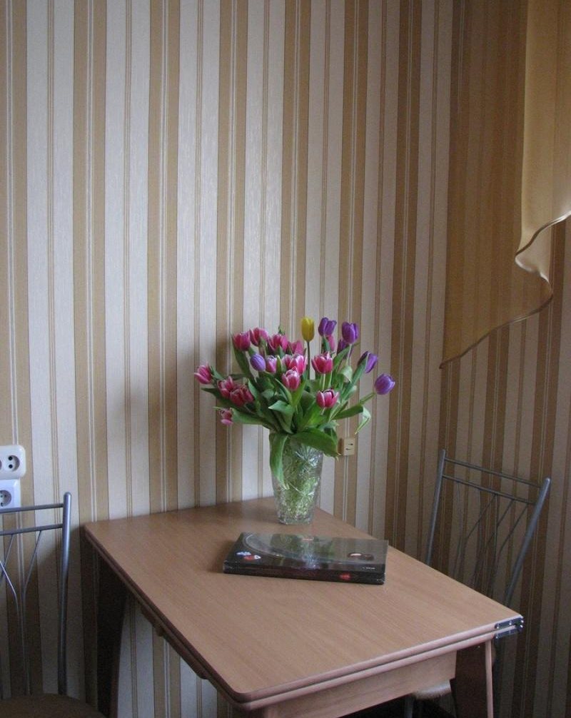 Jedálenský stôl pri stene s pruhovanou tapetou