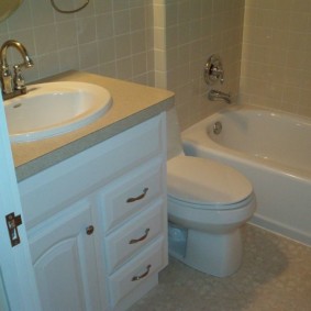 Armoire avec lavabo près de la porte dans la salle de bain