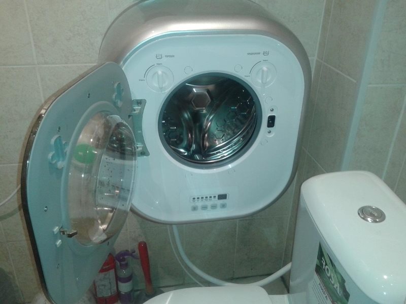 Kompaktiška skalbimo mašina ant sienos vonios kambaryje