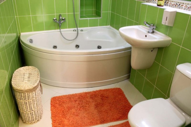 Oranžinis kilimas ant baltų grindų mažame vonios kambaryje