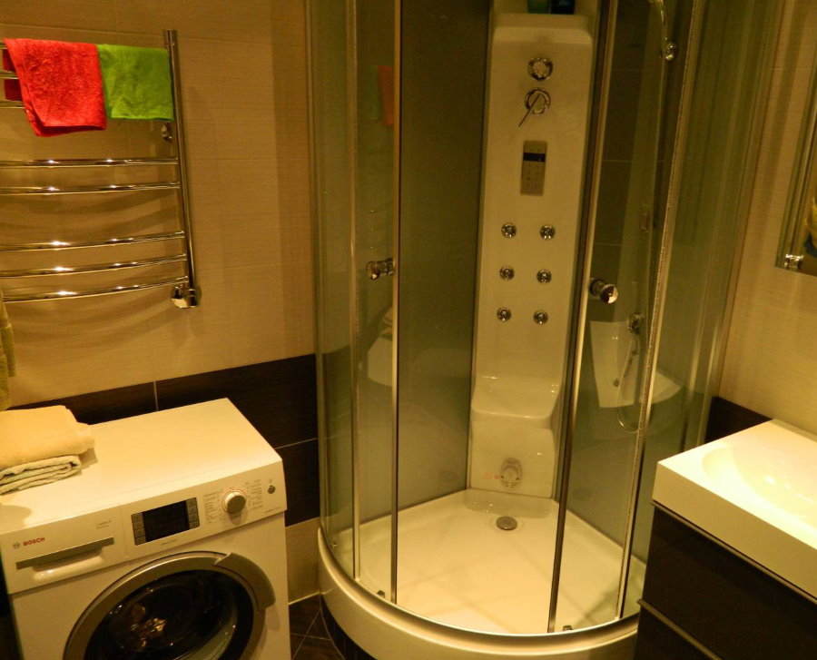 תא מקלחת קומפקטי בחדר האמבטיה עם מכונת כביסה