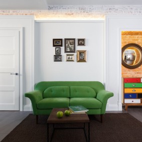 أريكة خضراء بجانب الجدار الأبيض لغرفة المعيشة