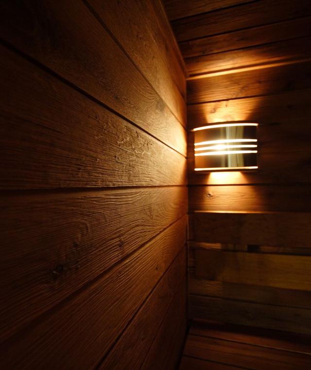 Posebna svjetiljka na drvenom zidu saune